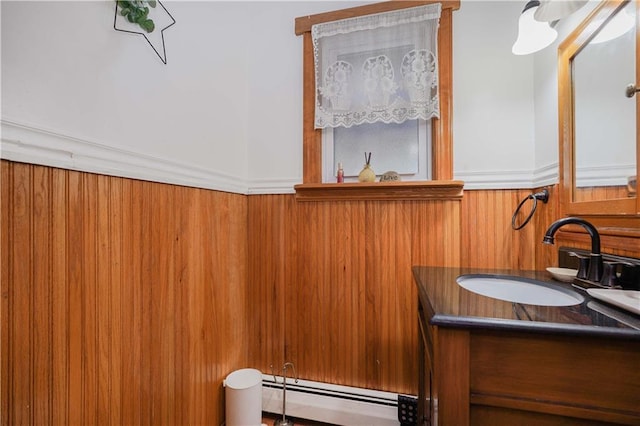 bathroom featuring vanity, wood walls, and a baseboard radiator