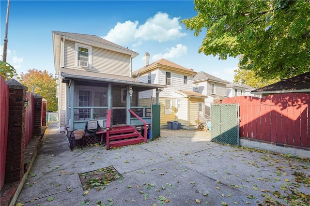 back of property with a sunroom and a patio