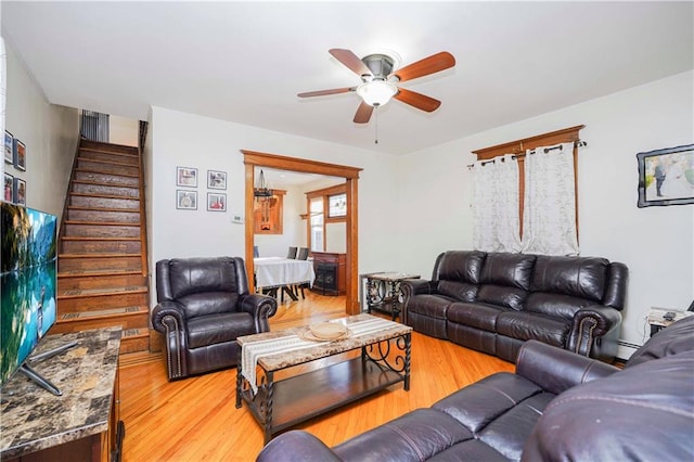 living room featuring hardwood / wood-style floors, baseboard heating, and ceiling fan