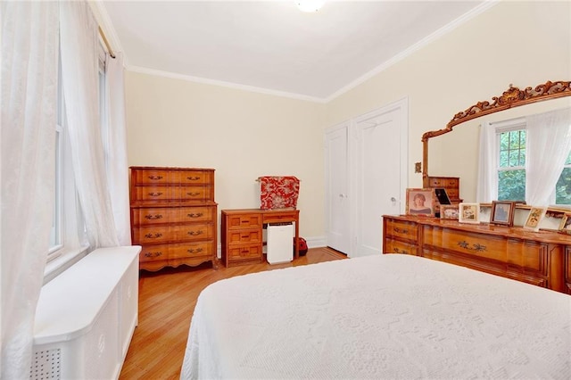 bedroom featuring a closet, ornamental molding, and light hardwood / wood-style flooring