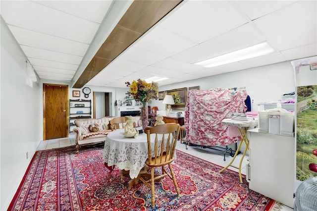 dining room with a drop ceiling and light tile patterned flooring