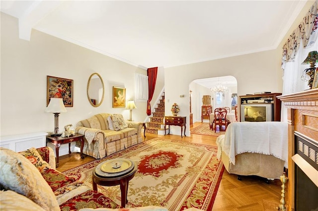 living room featuring crown molding, light parquet flooring, and a notable chandelier