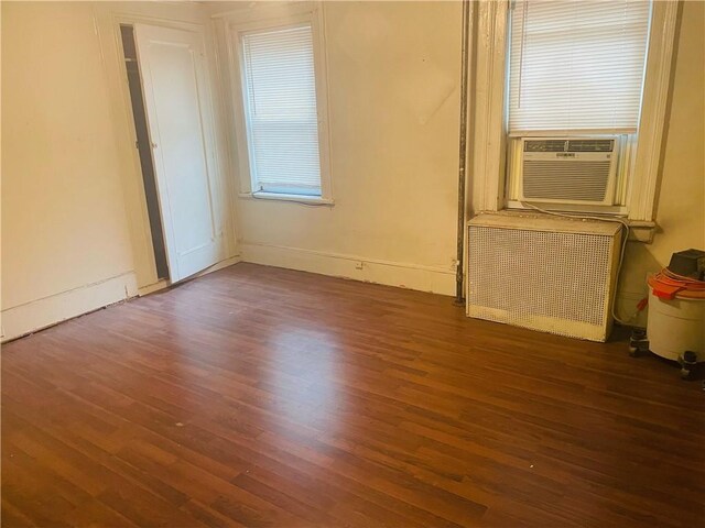 empty room with cooling unit and dark hardwood / wood-style floors