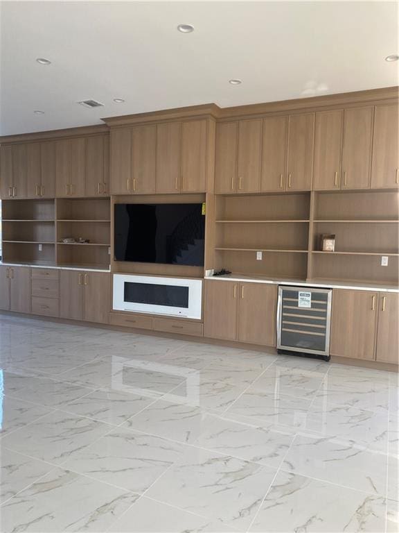 unfurnished living room with wine cooler, recessed lighting, visible vents, and marble finish floor