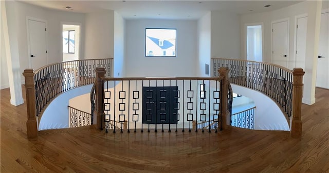 stairway with baseboards, wood finished floors, and a wealth of natural light