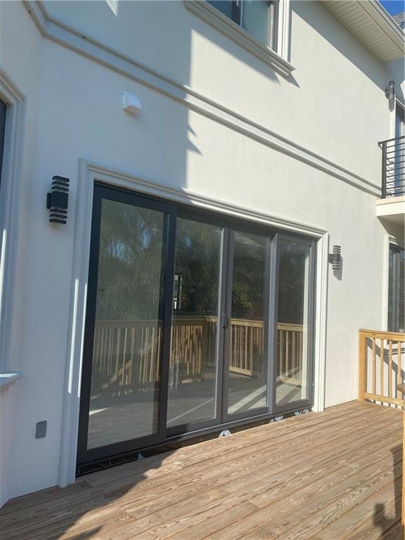 exterior space featuring a deck, french doors, and stucco siding