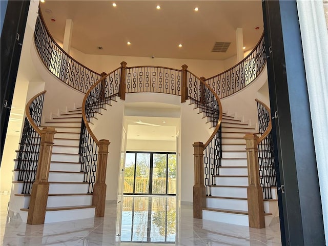 entryway with a high ceiling, recessed lighting, visible vents, and marble finish floor