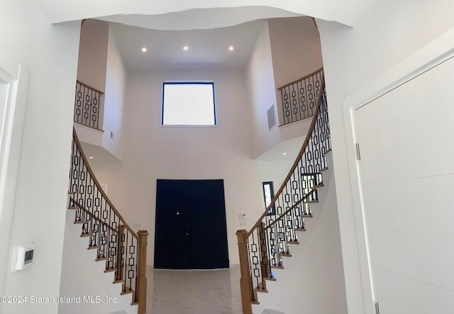 foyer entrance featuring stairway, visible vents, a high ceiling, recessed lighting, and marble finish floor