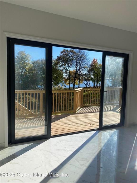 doorway to outside featuring plenty of natural light and marble finish floor