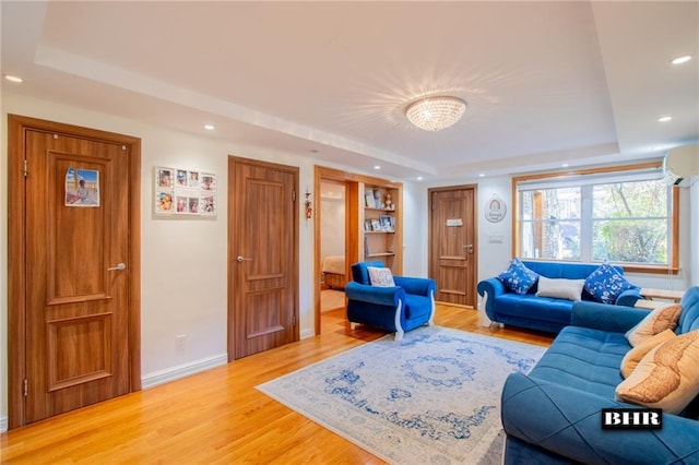 living room featuring a raised ceiling and hardwood / wood-style floors