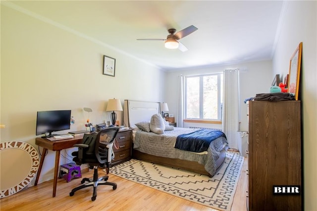 bedroom with crown molding, hardwood / wood-style floors, and ceiling fan