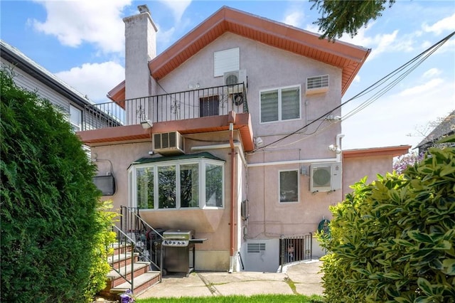 rear view of property featuring a balcony