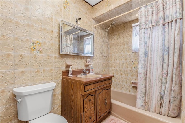 full bathroom with vanity, toilet, tile walls, and shower / tub combo with curtain