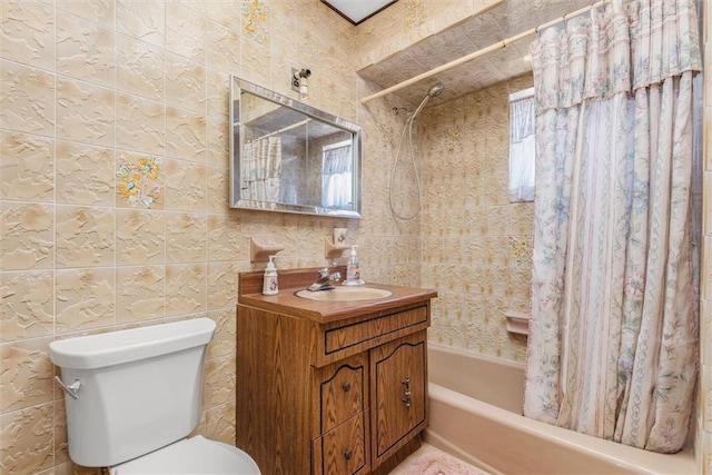 bathroom with shower / bathtub combination with curtain, toilet, vanity, and tile walls