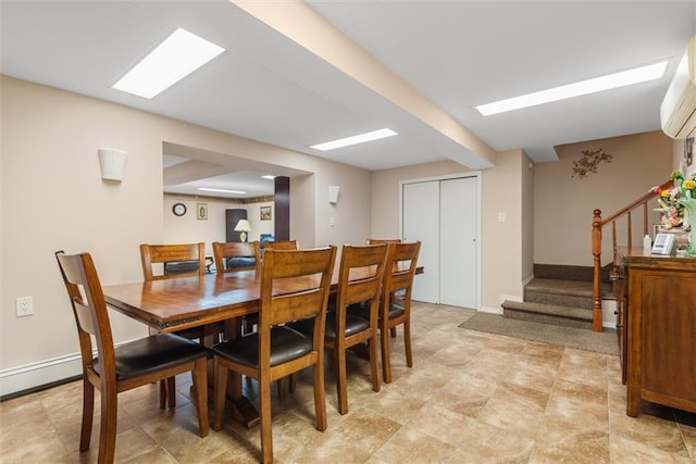 dining room with stairs, a wall unit AC, and baseboards