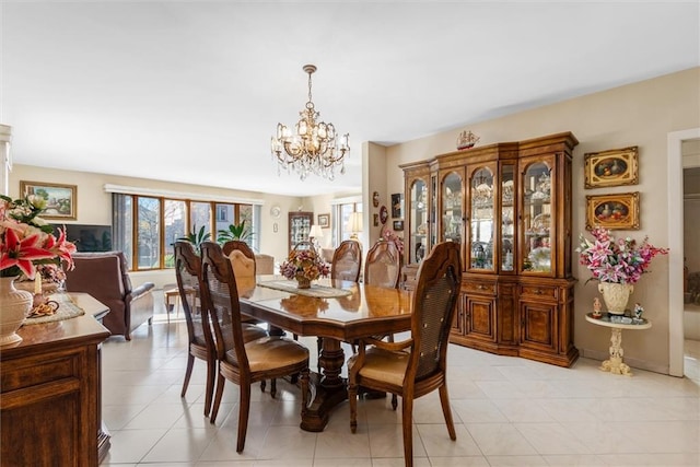 tiled dining room featuring an inviting chandelier