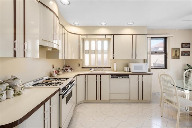 kitchen with sink, white cabinets, and white appliances