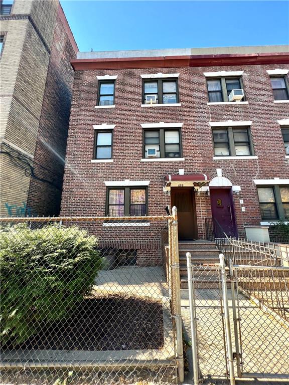 townhome / multi-family property with a gate, brick siding, and a fenced front yard