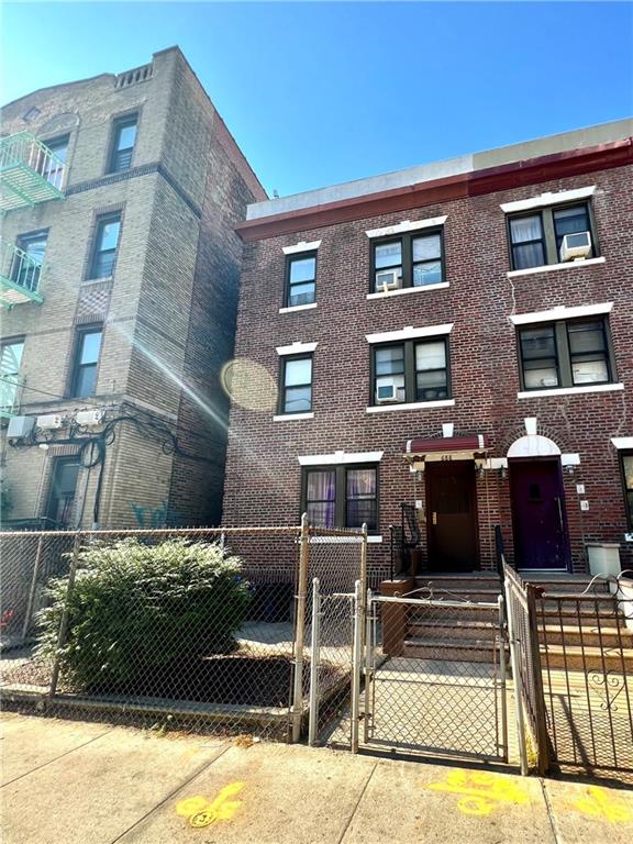 townhome / multi-family property with a gate, brick siding, and a fenced front yard