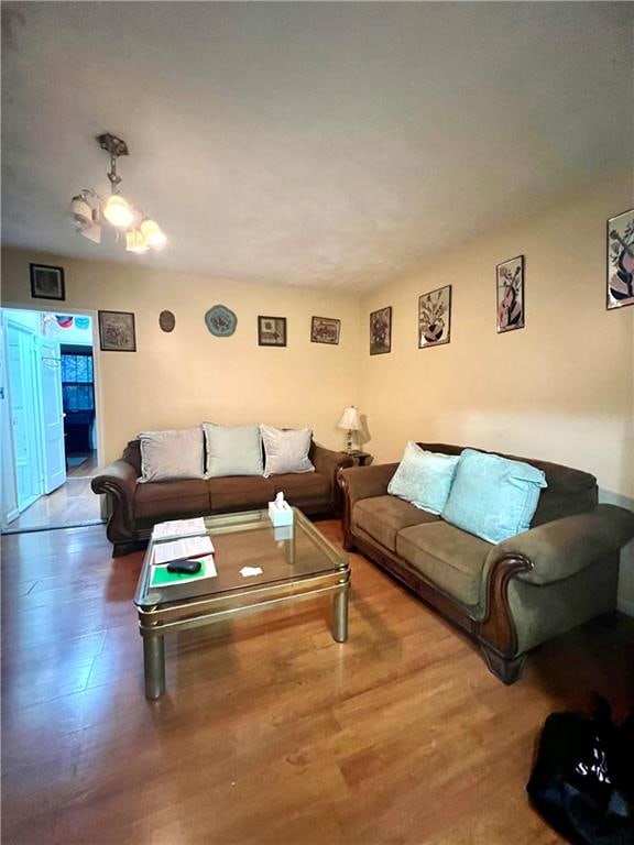 living room with wood finished floors and a notable chandelier