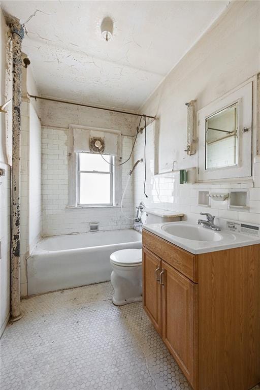 full bathroom with backsplash, vanity, tiled shower / bath combo, and toilet