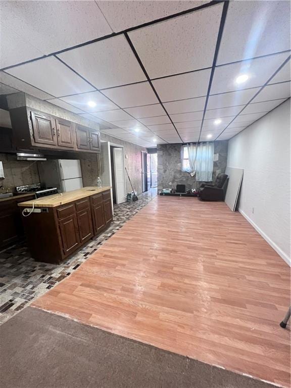 3708 Shore Pkwy, Brooklyn, NY 11235 - kitchen with dark brown cabinetry, light wood finished floors, a drop ceiling, open floor plan, and light countertops
