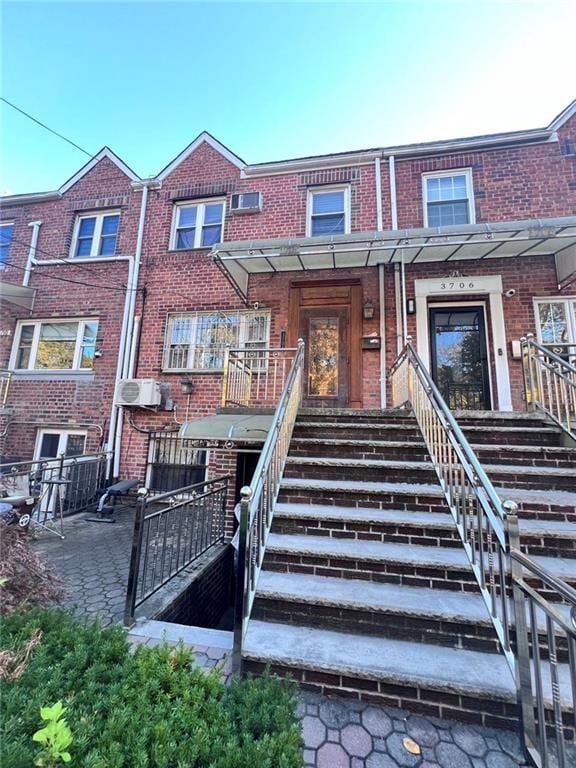 view of front of house featuring brick siding and stairway