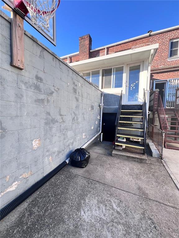 3708 Shore Pkwy, Brooklyn, NY 11235 - rear view of property with stairs, concrete block siding, and fence
