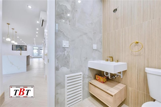 bathroom featuring sink, tile walls, and toilet