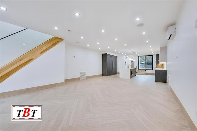 unfurnished living room featuring a wall mounted AC and light parquet floors