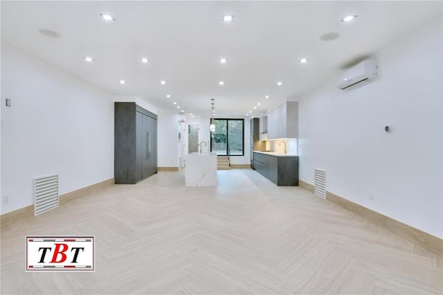 living room with a wall mounted AC, sink, and light parquet floors