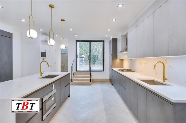 kitchen featuring decorative light fixtures, gray cabinets, and sink