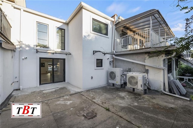 back of house with ac unit, a balcony, and a patio