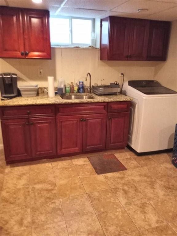 clothes washing area featuring cabinets, washer / clothes dryer, and sink