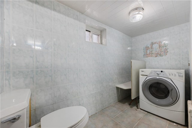 half bath featuring washer / clothes dryer, tile walls, and toilet