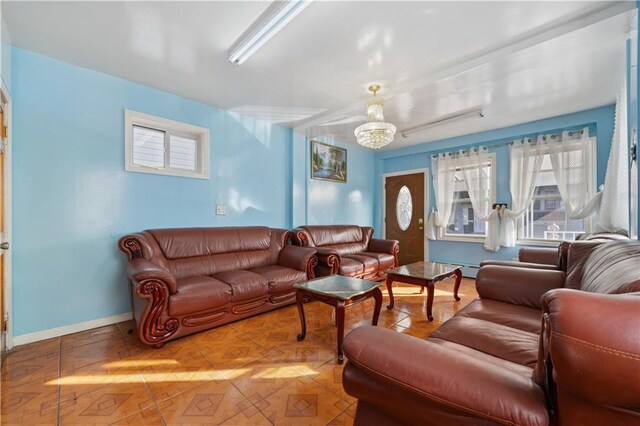 living room featuring a notable chandelier and parquet flooring