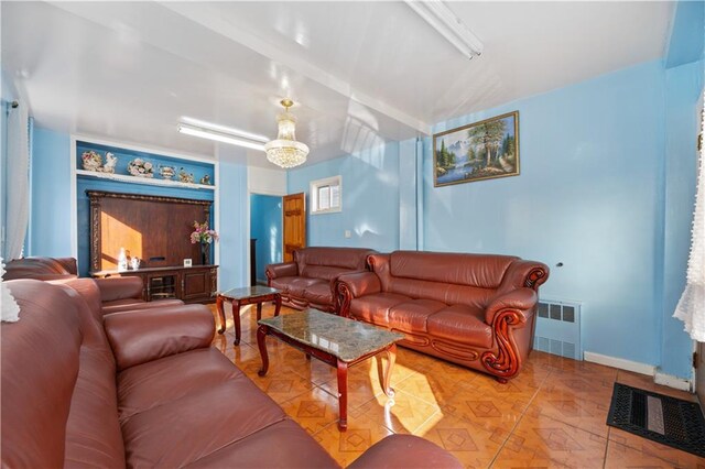 living room with radiator and an inviting chandelier