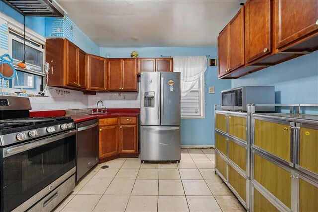 kitchen featuring light tile patterned floors, stainless steel appliances, and sink