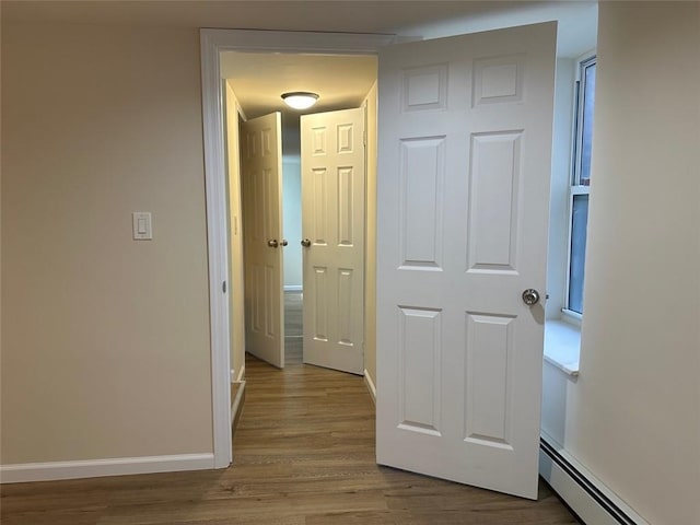 hallway featuring light hardwood / wood-style floors and a baseboard heating unit