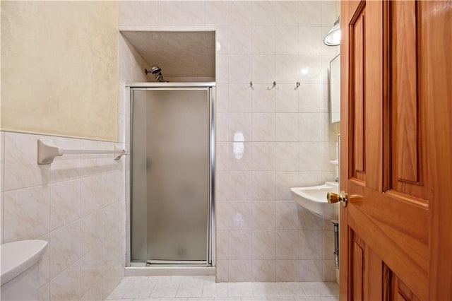 full bathroom with toilet, a stall shower, and tile walls