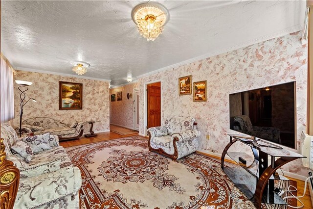 living area with a textured ceiling, wood finished floors, and wallpapered walls