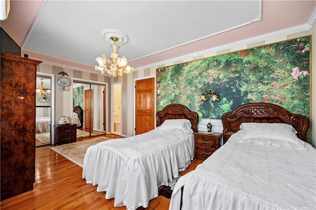 bedroom featuring a chandelier, crown molding, and wood finished floors