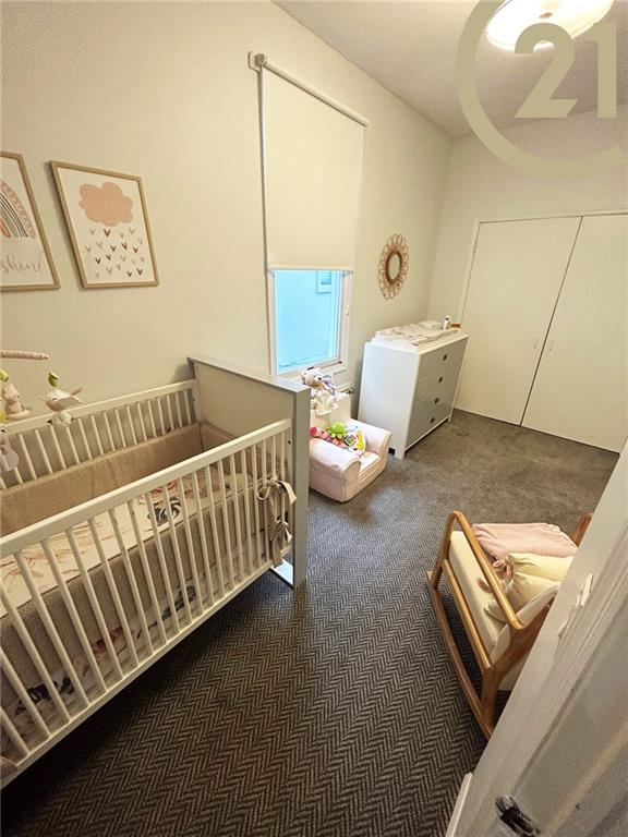 carpeted bedroom with a nursery area