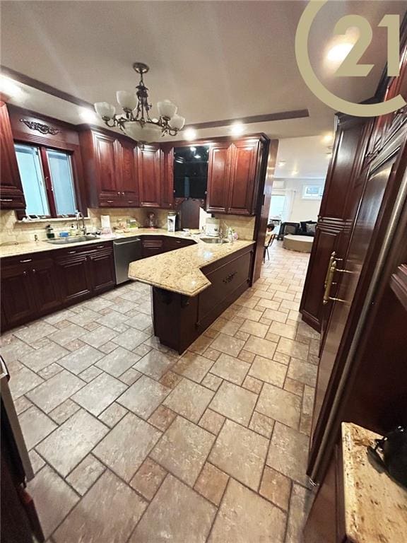 kitchen with dishwasher, sink, an inviting chandelier, light stone counters, and decorative light fixtures