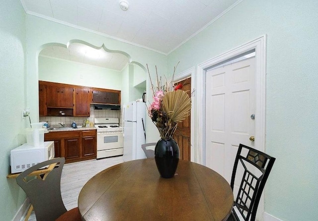 dining room with ornamental molding and sink