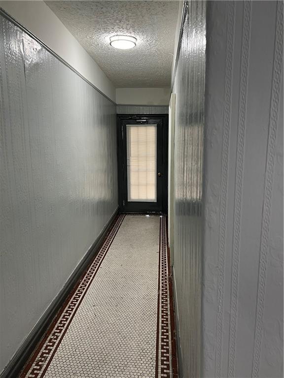 hallway with a textured ceiling