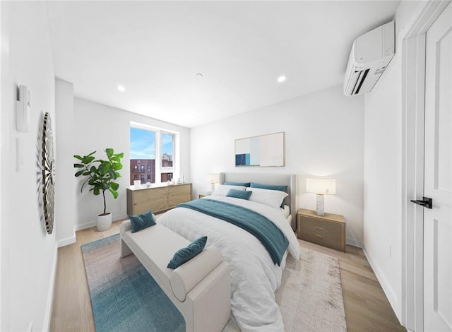 bedroom featuring baseboards, light wood finished floors, a wall mounted AC, and recessed lighting