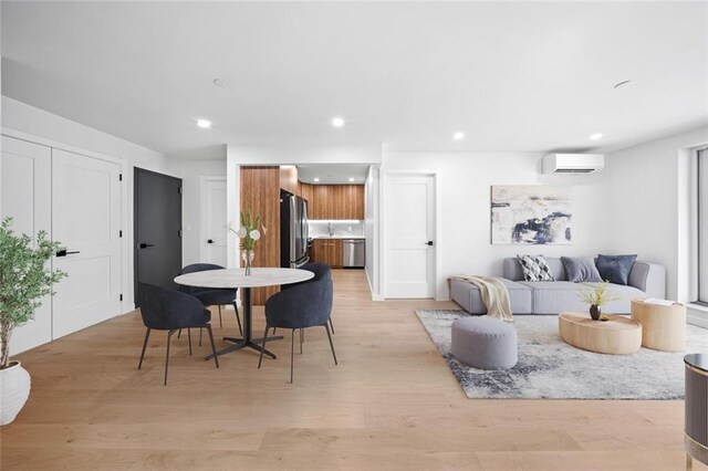 dining area featuring light hardwood / wood-style flooring and a wall mounted AC