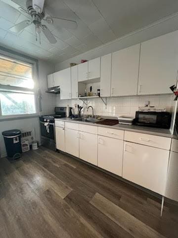 kitchen featuring black appliances, white cabinets, sink, dark hardwood / wood-style flooring, and extractor fan