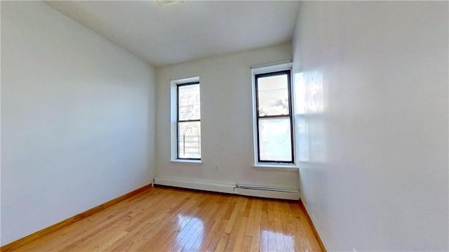 empty room featuring light wood-type flooring and baseboard heating